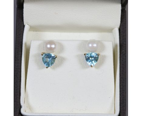 A pair of 9ct and blue topaz triangular earrings and a pair of pearl studs.