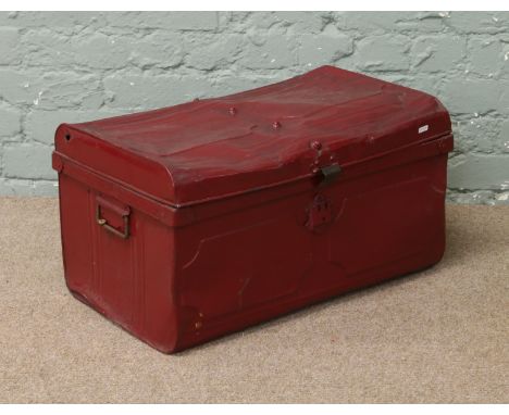 A red painted tin travelling trunk.