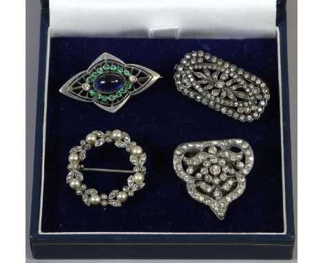 A silver Art Deco paste set openwork brooch and four similar including a seed pearl wreath brooch.