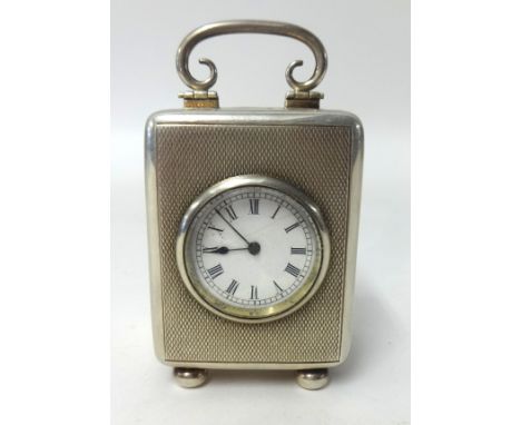 A silver cased travel clock, with French movement and platform escapement, on bun feet, height 9.50cm with handle up.