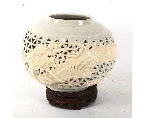 A Chinese ceramic pierced bowl, with dragon decoration, on carved wood stand, height 27cm overall 
