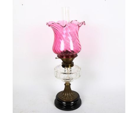 An Antique oil lamp with cut-glass font and cranberry glass shade, height 55cm 