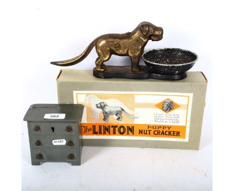 A novelty tinplate chest of drawers money bank, and The Linton Puppy nutcracker (2) 