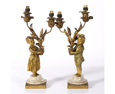 Pair of Louis XVI ormolu and white marble two light candelabra circa 1775, cast as a two figures holding a flower pot bearing