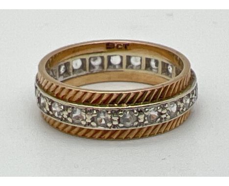 A 9ct gold full eternity ring set with a row of cubic zirconias and with diamond cut detail. Marked '9ct' inside band. Ring s