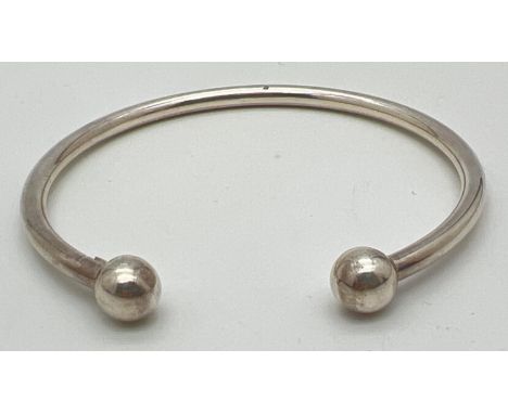A 925 silver torque bangle, approx. 6.5cm diameter. Stamped 925 on panel near to ball finial. 