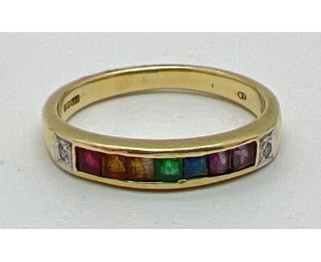 A 14ct gold ring set with 7 square cut channel set rainbow gemstones and flanked by diamonds. Gemstones include: Ruby, citrin