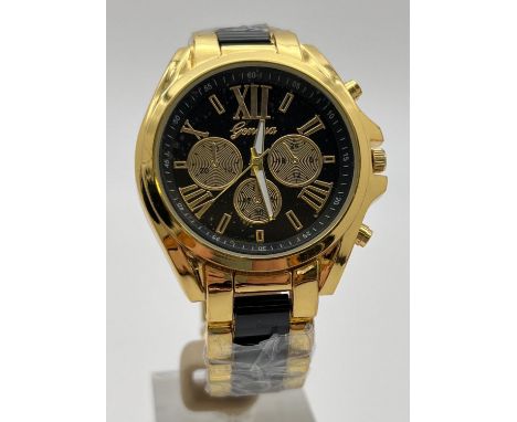 A new, with original wrap, mens gold tone and black link chronograph wrist watch by Geneva. Luminous hands and seconds hand f