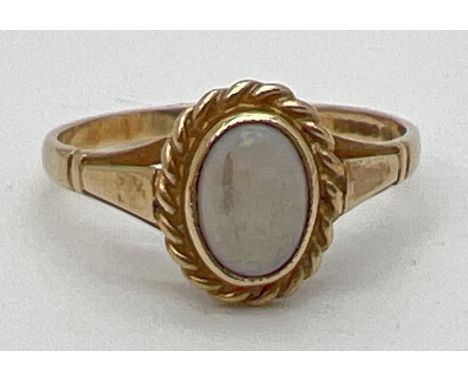 A 9ct yellow gold dress ring set with central oval opal in a twist setting. Fully hallmarked inside band. Ring size M. 