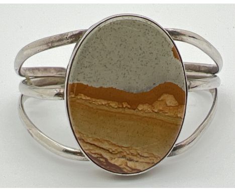 A vintage silver cuff style bangle set with a large oval cut agate stone. Back marked Sterling. Stone approx. 4 x 3cm. 