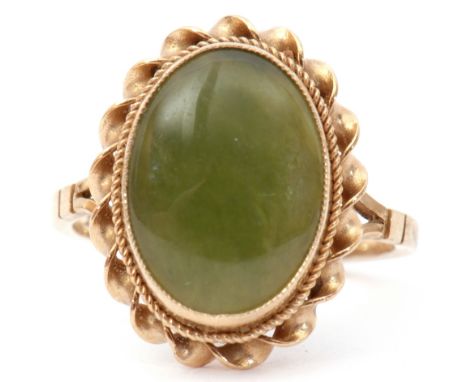 Late 20th century 9ct gold and jade ring, the oval shaped jade panel bezel set in a rope twist surround, London 1980, size K