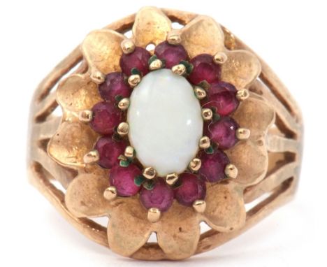 9ct gold opal and ruby set cluster ring, a design featuring an oval cabochon opal raised within a ruby surround between pierc