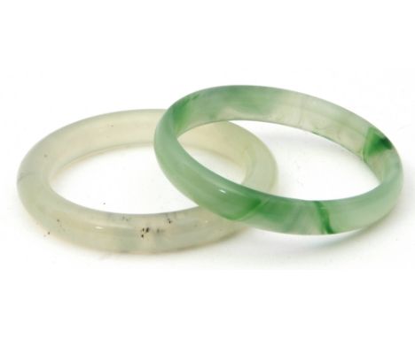 Mixed Lot: pale green jade bangle, 6cm diam (interior) together with a pale celadon quartz bangle (2)