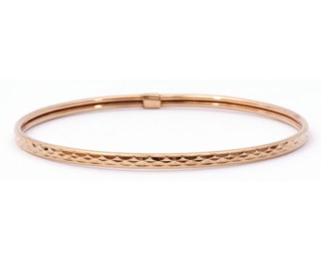 9ct gold bangle with a continuous stylised engraved design, 7cm diam, 3.7gms