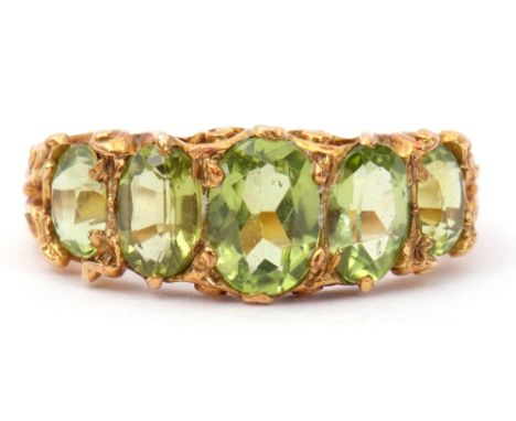 9ct gold five stone peridot ring, featuring five graduated oval cut peridots, claw set in carved gallery to a threaded shank,