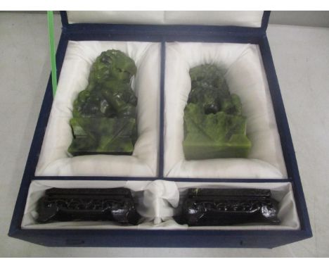 A pair of late 20th Century Chinese jade coloured Foo dogs, on stands boxed 