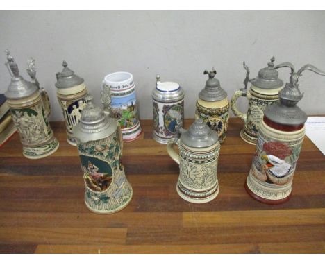 Nine German ceramic beer steins, the majority with cast metal hinged lids 