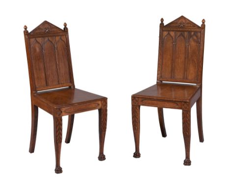  A pair of William IV carved oak hall chairs  , circa 1830, of small scale, in the gothic revival style, the triangular crest