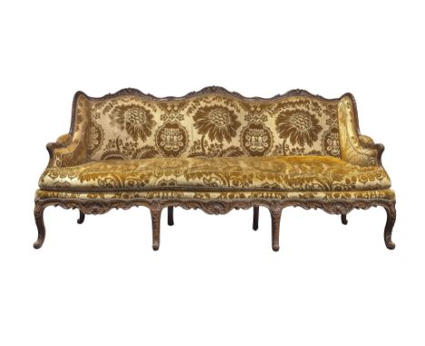 A Louis XV Carved Walnut Settee, circa 1730, with an elaborate serpentine frame carved with acanthus, shells and cabochons, n