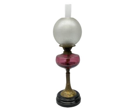 Victorian table standing oil lamp, brass fittings, cranberry glass reservoir, brass column on black enamelled ceramic base, w