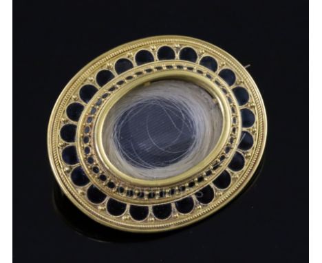 A Victorian gold and black enamel oval mourning brooch, with hair beneath a glazed panel and beaded enamel border, inscribed 