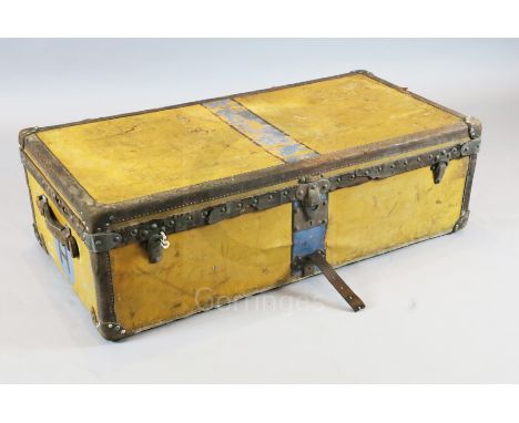 A 1920's Louis Vuitton travelling trunk, with orange yellow covering and brass studded brown leather banding, the interior wi