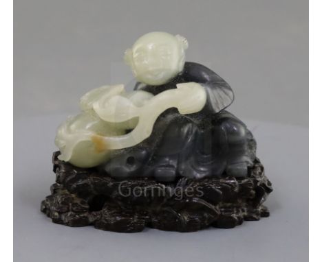 A Chinese pale celadon and grey jade figure of a seated boy, holding a gourd and bat to one side the carver skillfully using 