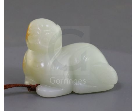 A Chinese white jade figure of a recumbent lion-dog, possibly 18th century, The stone of good even tone with a russet skin to