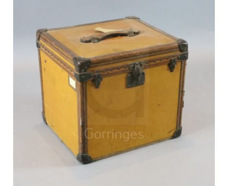A 1920's Louis Vuitton small travelling trunk, with tan orange leather bound by brass studded brown leather banding, label fo