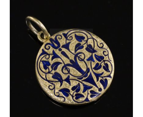 A Victorian gold and blue enamel mourning pendant locket, with scrolling arabesque decoration and opening to reveal a lock of