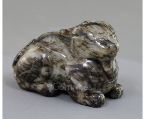 A Chinese pale grey and black jade recumbent figure of a lion-dog, length 8.3cm