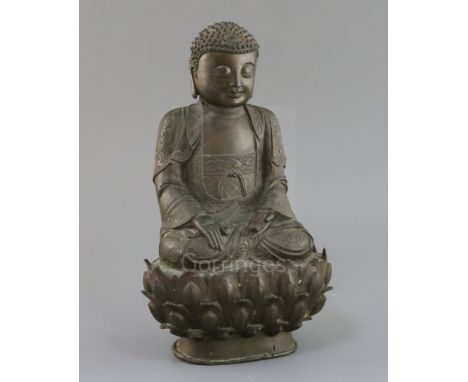 A Chinese bronze seated figure of Buddha Shakyamuni, 17th century, with tightly knotted hair, flower engraved robes, on a lot