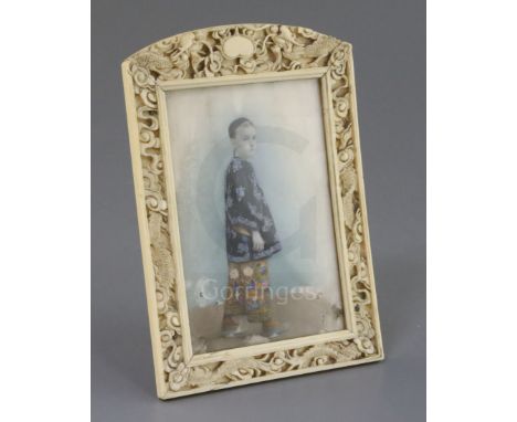 Chinese School, late 19th century, portrait miniature of a boy in an ivory frame, painted with a full length portrait of a Eu