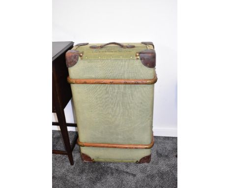 A large vintage green ribbed travel trunk with leather handles and padded corners, previous owners initials printed to the to