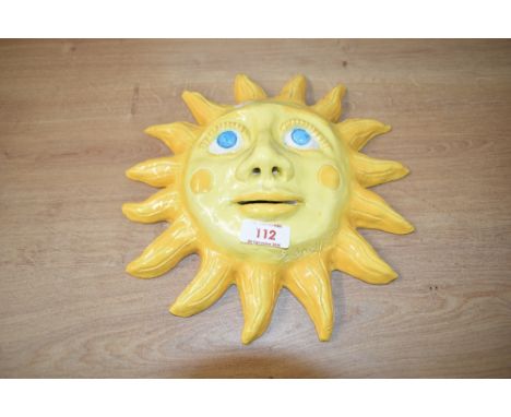 A mid 20th century hand made ceramic sun plaque, signed 'Rodney Y.C', w30cm.
