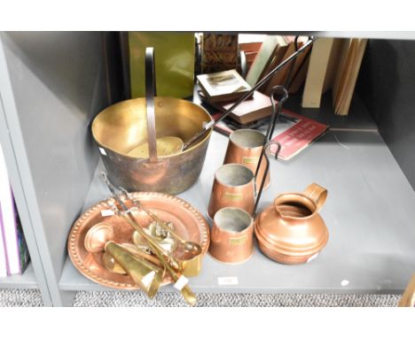 A collection of brass and copper utensils, to include a set of three graduating cider measures with iron handles, a large jam