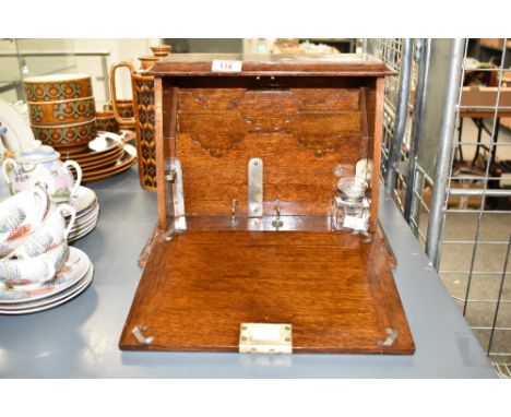 A late 19th / early 20th century oak cased fall front stationary box / writing case, complete with glass inkwell, plate fitti