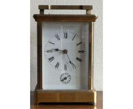 A large brass carriage clock with white enamel dial. Est. £30 - £50.