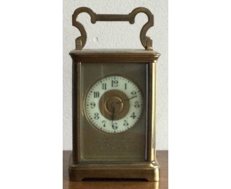 A large brass carriage clock with white enamel dial. Est. £30 - £50.