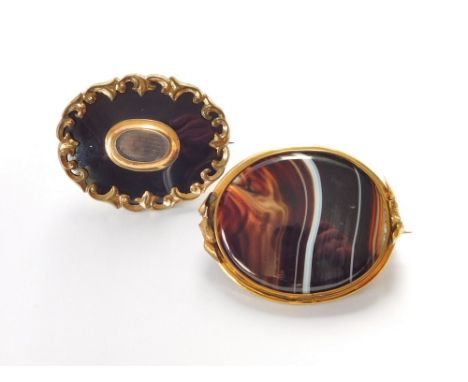 MOURNING BROOCH ETC. A Victorian black enamel mourning brooch in gold plated mount & one other large brooch, set with banded 