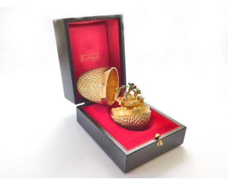 STUART DEVLIN.  A Stuart Devlin textured silver gilt Surprise egg, opening to reveal a red enamelled silver robin, 'en trembl