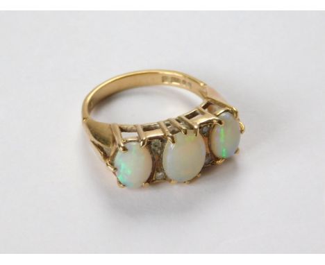 OPAL RING. A 9ct. gold ring set three large oval opals & four small diamonds. Approx. 4.1g. Size M/N.  Please note that all i