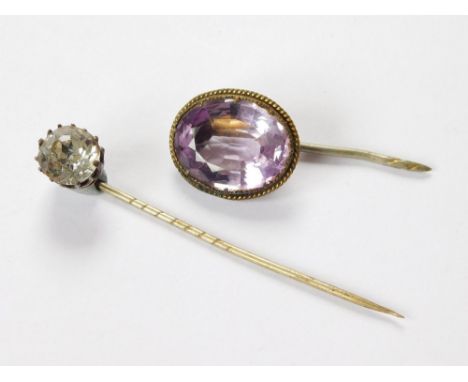 STICK PINS. An amethyst set stick pin & one other stick pin, set a clear paste stone.  Please note that all items in this auc