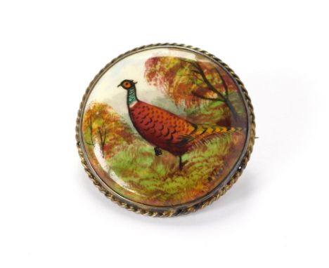 PHEASANT BROOCH. A ceramic brooch, hand painted with a pheasant in a landscape, the reverse stamped (As)tra (?). Gilt metal m