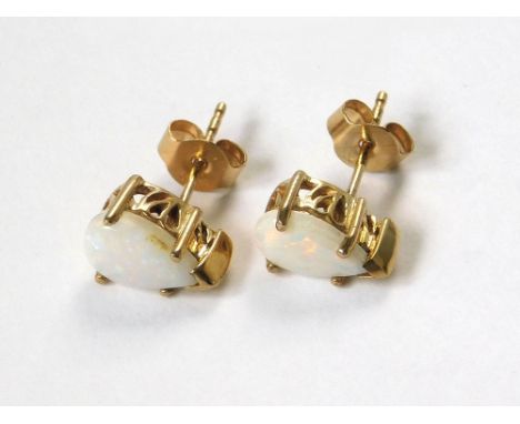 OPAL EARRINGS. A pair of 9ct. gold, opal set stud earrings.  Please note that all items in this auction are previously owned 