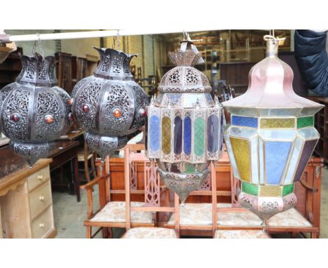 A Moroccan copper and stained glass octagonal hanging lantern and a pair of pierced bronzed metal lanterns (3) and another, l
