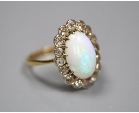 An early to mid 20th century 18ct, white opal and diamond set oval cluster ring, size K, gross 3.1 grams.