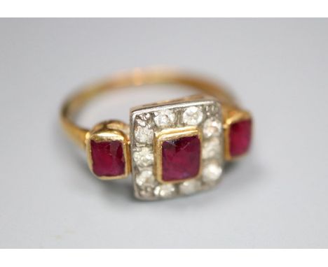 An early 20th century yellow metal, ruby and diamond cluster ring with ruby set shoulders, size K, gross 3.6 grams.