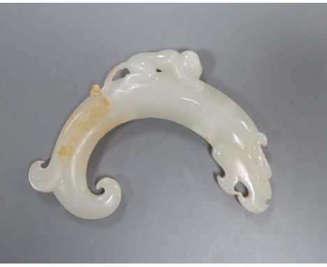 A Chinese archaistic white and russet jade plaque, 9.5cm, carved with a monkey