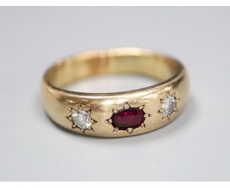 A yellow metal and gypsy set ruby and diamond three stone ring, size U/V, gross 8.9 grams.